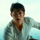 Tom Holland as Nathan Drake in Uncharted, standing on an open cargo platform.
